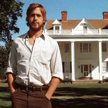 a man in a white shirt stands in front of a white house