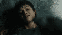 a woman is laying on the ground with blood coming out of her face .