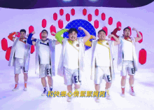 a group of men wearing shorts with the letter e on them are dancing