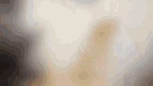 a blurred image of a person standing in a room with a white background .