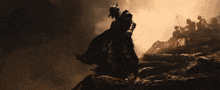 a silhouette of a man in a cape walking up a hill
