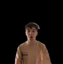 a man in a yellow shirt is making a surprised face with his hands in the air .