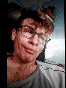 a man with glasses is smiling and laying down