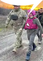 a woman wearing a pink hello kitty vest is walking with a man in a military uniform