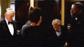 a group of men in tuxedos and bow ties are standing around a woman in a black dress