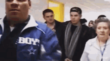a man wearing a blue jacket that says boy