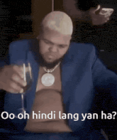 a man in a blue suit is holding a glass of wine and says `` oo oh hindi lang yan ha '' .