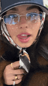 a woman wearing glasses a scarf and a hat