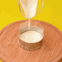 chocolate is being poured into a tin on a wooden plate