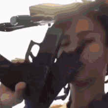 a close up of a person holding a gun to their face