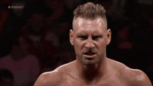 a man with a beard stands in front of a crowd with the hashtag #wwe nxt