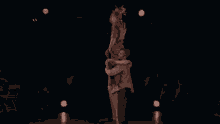 three people are hugging each other on a stage in a dark room