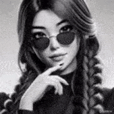 a black and white portrait of a girl wearing sunglasses and braids .