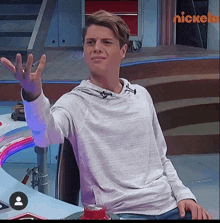 a man sitting in a chair with a nickelodeon logo in the background