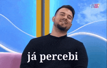 a man with a beard is sitting in front of a blue background and says ja percebi