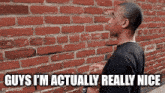 a man standing in front of a brick wall with the words `` guys i 'm actually really nice '' .