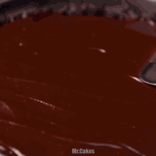 a chocolate cake on a wooden cutting board on a pink background