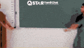 a man stands in front of a star tamil chat board