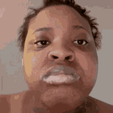 a close up of a woman making a funny face with her mouth full of milk .
