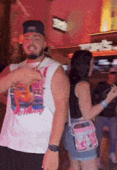 a man wearing a shirt that says ' birthday ' on it is dancing with a woman