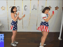 two women are dancing in front of a wall with roar balloons