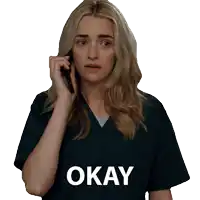 a woman is talking on a cell phone and the word okay is on the shirt