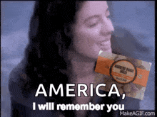 a woman is holding a box of assorted donuts in front of her face and says " america i will remember you "