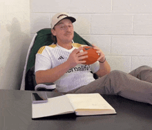a man wearing a herbalife jersey holds a football