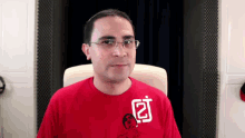 a man wearing glasses and a red t-shirt with the letter j on it