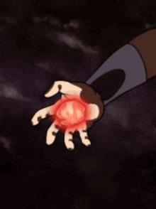 a person is holding a red object in their hand that looks like a heart .