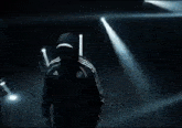a man in an adidas jacket is walking through a dark room .