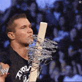 a man with barbed wire in his mouth is wearing a black shirt with the word evolve on it