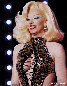 a woman with blonde hair is wearing a leopard print top with a plunging neckline