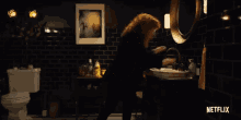 a woman with red hair is standing in a dark room with a netflix logo in the background .