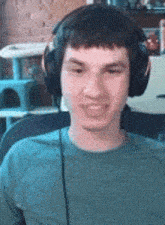 a young man wearing headphones is sitting in a chair and smiling .