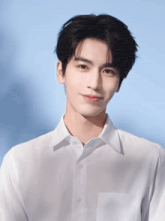 a young man in a white shirt is looking at the camera with a blue background