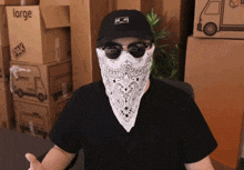 a man wearing sunglasses and a bandana is standing in front of boxes that say large