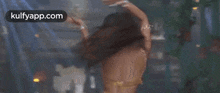 a woman in a bikini is dancing in a dark room in front of a crowd .