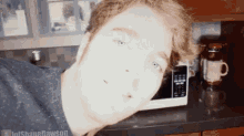a man is taking a picture of himself in front of a microwave in a kitchen ..