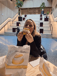 a woman sitting at a table with a bag of goda semlor on it
