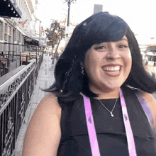 a woman wearing a purple lanyard that says vegas on it smiles