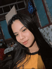 a girl in a yellow shirt looks at the camera