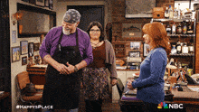 a group of people standing in a room with a nbc logo on the bottom