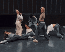 a group of women are dancing on a stage and one of them is wearing a hoodie