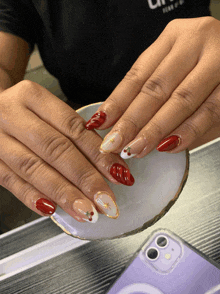 a close up of a person 's nails with a phone in the background that says ' l ' on it
