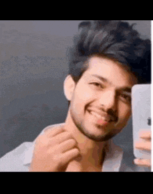 a young man is taking a picture of himself with his phone .
