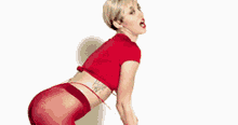 a woman with a tattoo on her back is wearing red tights and a red shirt
