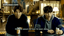 two men are sitting at a table and one of them is saying she also asked me how i 'd been doing ..