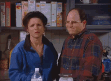 a man and a woman are standing in a kitchen and the woman is making a funny face