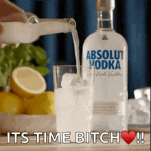 a bottle of absolut vodka is poured into a glass with ice